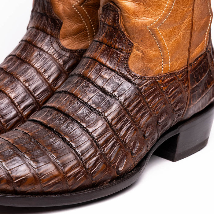 Brown crocodile leather cowboy boots with aged maple finish. Round toe, detailed stitchwork, and a sturdy black heel. Richly textured vamp, traditional Western design.
