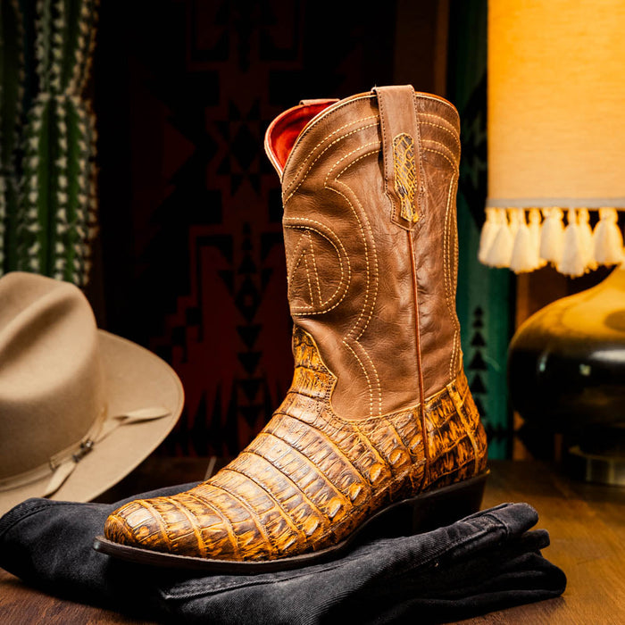Marco Di Milano Phoenix cowboy boots. Mustard brown caiman crocodile upper, black heel & sole. Round toe, detailed stitching, pull tabs. Sleek silhouette.
