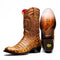 Marco Di Milano cowboy boots in mustard brown caiman crocodile. Round toe, decorative stitched brown leather upper. Branded sole, moderate heel, and textured patterns.

