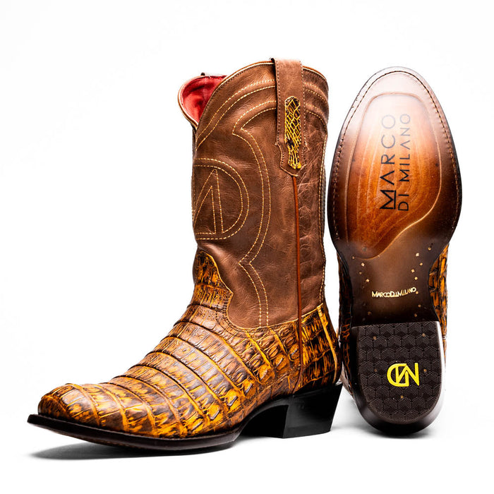Marco Di Milano cowboy boots in mustard brown caiman crocodile. Round toe, decorative stitched brown leather upper. Branded sole, moderate heel, and textured patterns.
