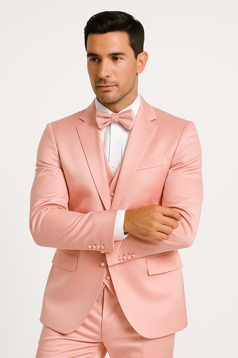 Light pink tuxedo set: fitted satin blazer, matching trousers, white dress shirt, and bow tie. Features notched lapel, side pockets, and a visible waistcoat. Shirt with contrasting white cuffs.

