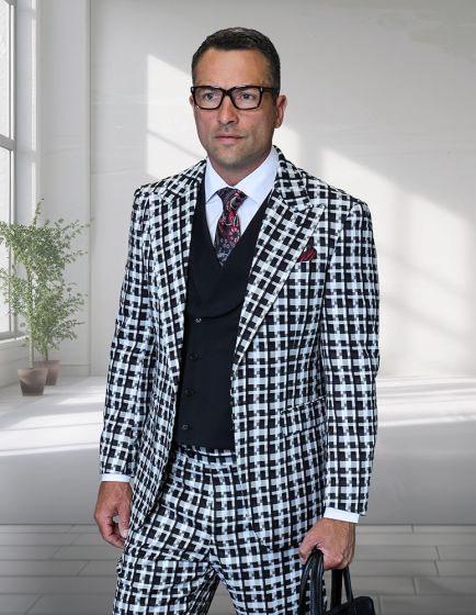 The Statement mens 3 piece suit features a unique checker pattern in black and white. It is composed of 100% wool. The suit includes a jacket with peak lapels, a matching waistcoat, and tailored trousers. The formal elements are structured and fitted.