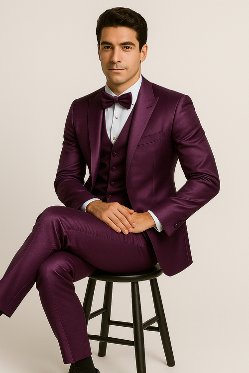 Alberto Nardoni's purple tuxedo set: single-breasted jacket, trousers, waistcoat. Smooth, shiny purple fabric. Notched lapel, buttons, bow tie, and light blue dress shirt. Formal, straight-cut trousers.
