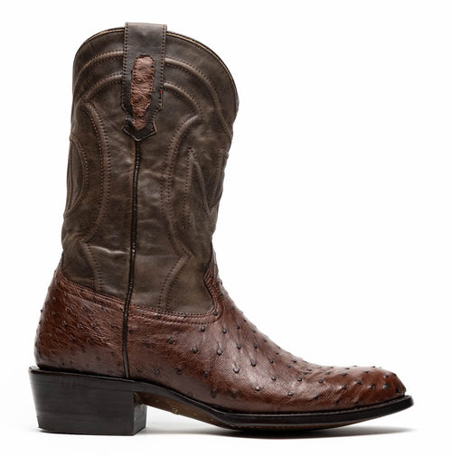 Marco Di Milano Kango Tabae cowboy boots. Two-tone design: dark brown ostrich lower, contrasting upper. Tall silhouette, round toe, stacked heel. Decorative stitching. Leather construction with smooth shaft and textured foot. Pull tab.
