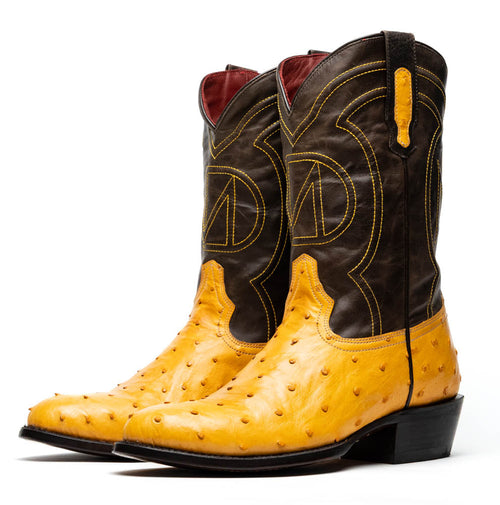 Marco Di Milano Savannah cowboy boots. Yellow ostrich quill leather body with dark brown shaft accents. Features yellow stitching, ornate side design, round toe, stacked heel, and pull tabs.
