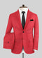 Red textured suit jacket (single-breasted, notched lapels, 2 pockets) with black tie and matching, neatly folded red trousers.