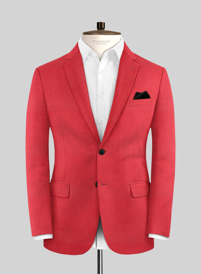 Red tailored suit jacket with notch lapel, two front pockets, and a chest pocket with black pocket square. Textured fabric, structured shoulders, single-button closure, and worn over a white shirt, creating a formal look.
