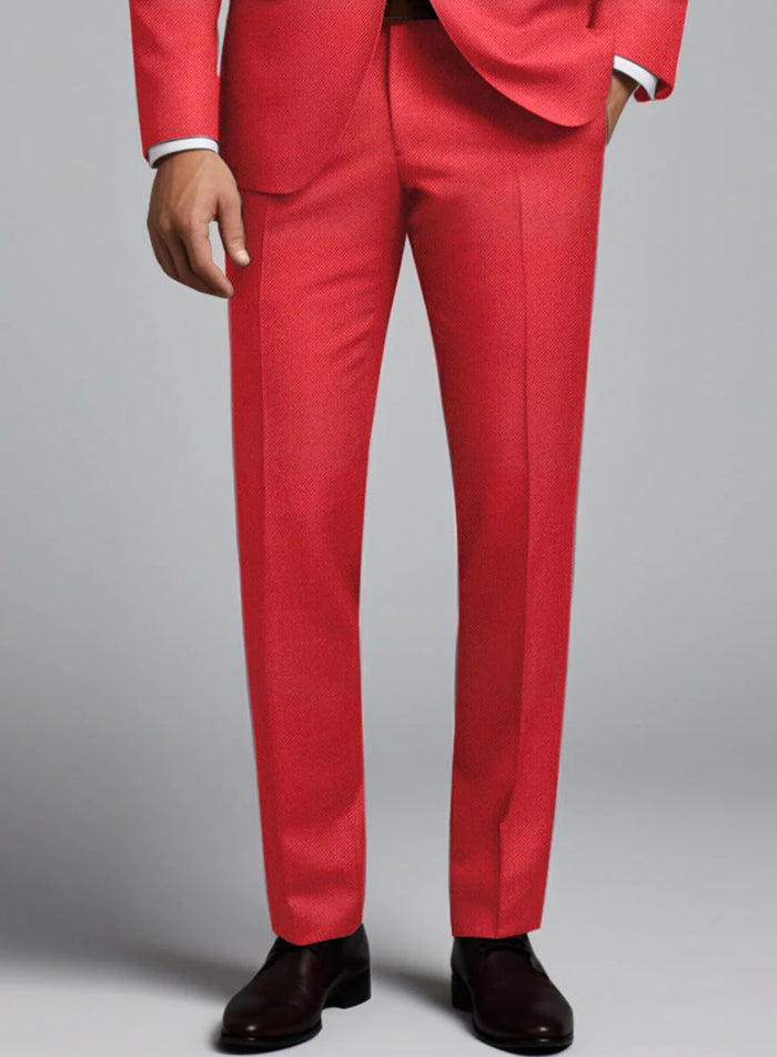 Tailored red suit with matching trousers. Straight cut, textured fabric. Slim-fit trousers with smooth finish. Black tie. Vibrant red color for a striking look.
