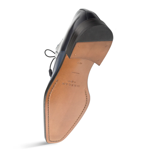 Mezlan Soka blue cap-toe shoes: calfskin deerskin upper, smooth leather, structured design. Tan leather sole with stitched edge and decorative elements. Lace-up, sleek silhouette.
