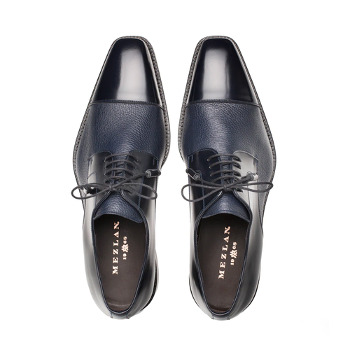 Dark blue Mezlan Soka cap-toe shoes. Calfskin and deerskin upper, polished cap toe, textured finish. Lace-up with thin laces, slightly raised sole, narrow stitching.
