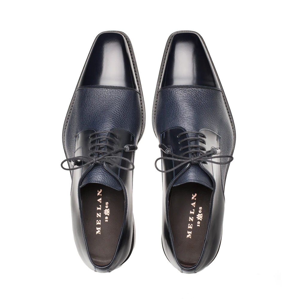 Dark blue Mezlan Soka cap-toe shoes. Calfskin and deerskin upper, polished cap toe, textured finish. Lace-up with thin laces, slightly raised sole, narrow stitching.
