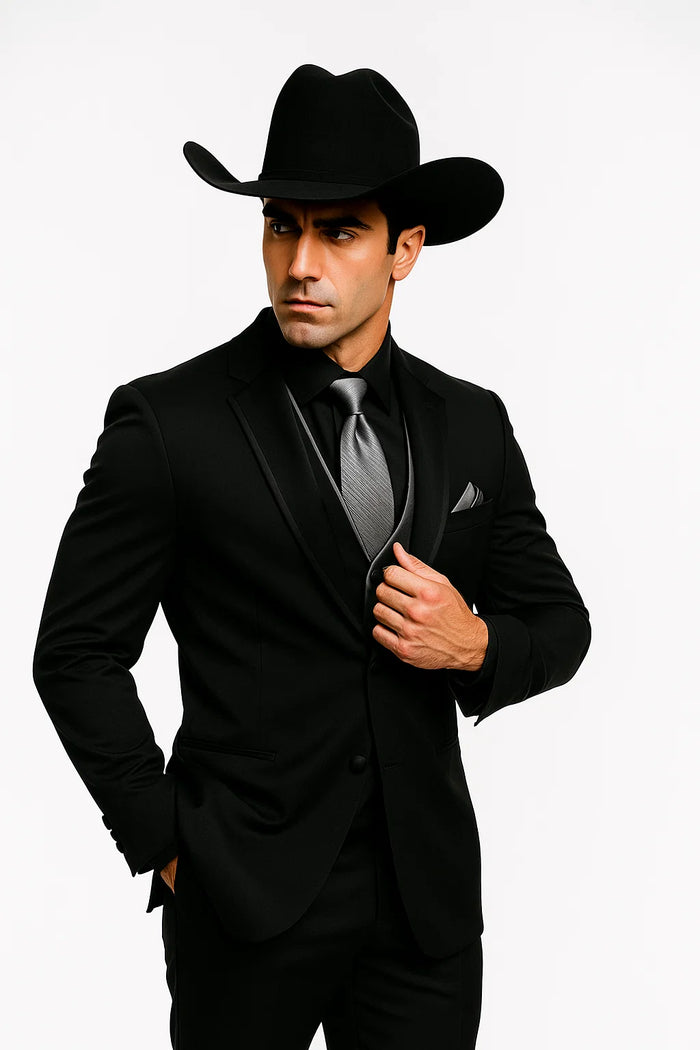 Men's black western tuxedo. Structured fit, satin peak lapel. Includes silver vest and wide-brimmed black cowboy hat. Classic western elegance.
