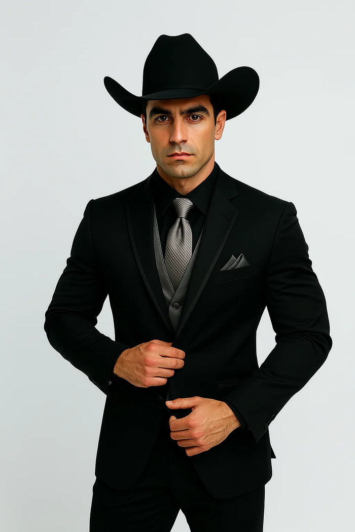 Men's black western tuxedo: fitted silhouette, smooth fabric. Silver vest & tie. Cowboy hat included. Classic western formal wear.
