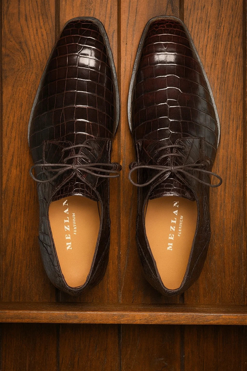Men's brown alligator derby shoes. Genuine alligator skin with a polished, textured finish. Elongated shape, lace-up closure, and sleek profile. Rich brown color.
