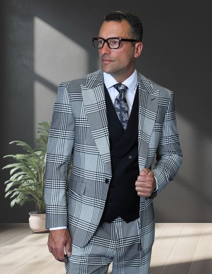 Tree-piece plaid suit made from 100% wool, featuring a modern fit. It includes a patterned blazer, a matching vest, and trousers. The color palette consists of light and dark shades of gray, creating a contrast in the plaid design.
