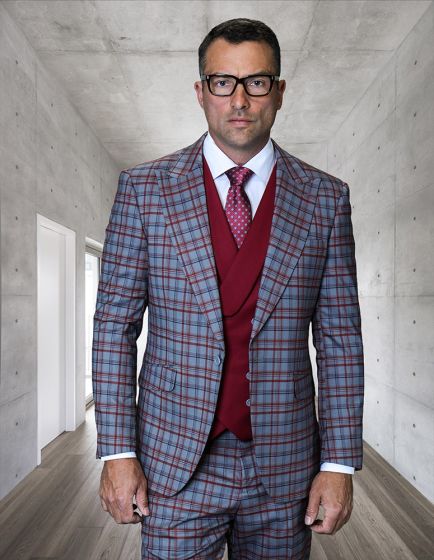 The Statement mens 3 piece plaid suit features a modern fit design made from 100% wool. The suit displays a gray, red, and navy plaid pattern with a tailored jacket, matching vest, and trousers. The jacket has a structured silhouette with peaked lapels.