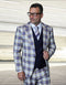 The Statement men's 3-piece plaid suit features a modern fit with a structured blazer, a waistcoat, and slim-fit trousers. The primary material is 100% wool, characterized by a multicolored plaid pattern in shades of blue, yellow, and white. The blazer has peaked lapels and front pockets.