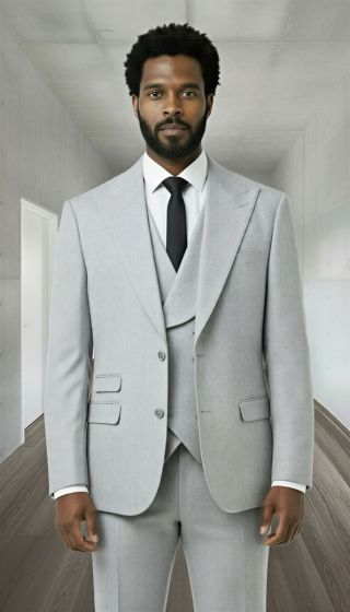 The Statement mens 3 piece modern fit suit features peak lapels, a double-breasted vest, and flat-front trousers. It is constructed from 100% wool and presented in a light grey color. The tailored fit emphasizes a structured silhouette with two front pockets on the jacket.