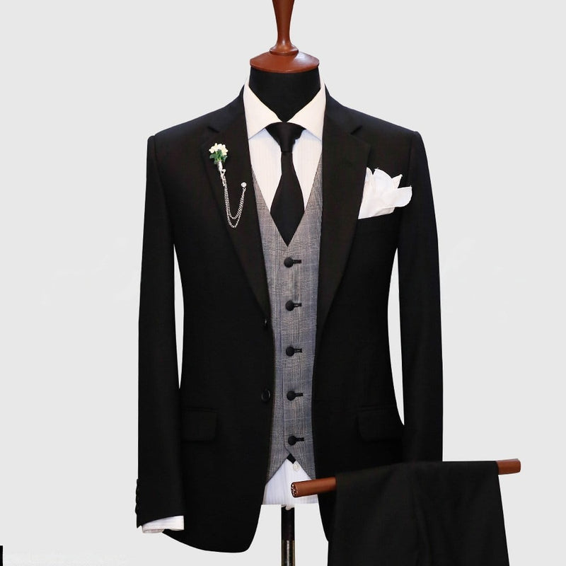 Black suit featuring a gray plaid vest by Alberto Nardoni. The suit jacket has a tailored fit with notched lapels and two front pockets. The gray plaid vest has five buttons and a double-breasted design. A white dress shirt and black tie are visible underneath the vest.