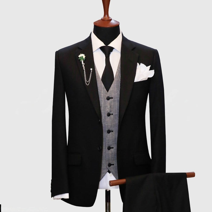 Black suit featuring a gray plaid vest by Alberto Nardoni. The suit jacket has a tailored fit with notched lapels and two front pockets. The gray plaid vest has five buttons and a double-breasted design. A white dress shirt and black tie are visible underneath the vest.