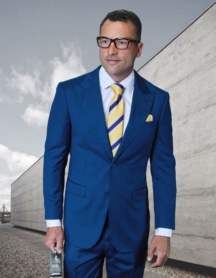 The Statement mens outlet 2 piece suit features a modern fit design made from 100% wool, showcased in a rich blue color. The suit includes structured lapels and is complemented by visible pic stitching details along the edges.